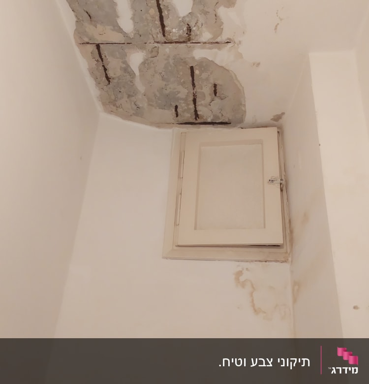 תקרה מתקלפת עם סימני רטיבות וקיר לבן